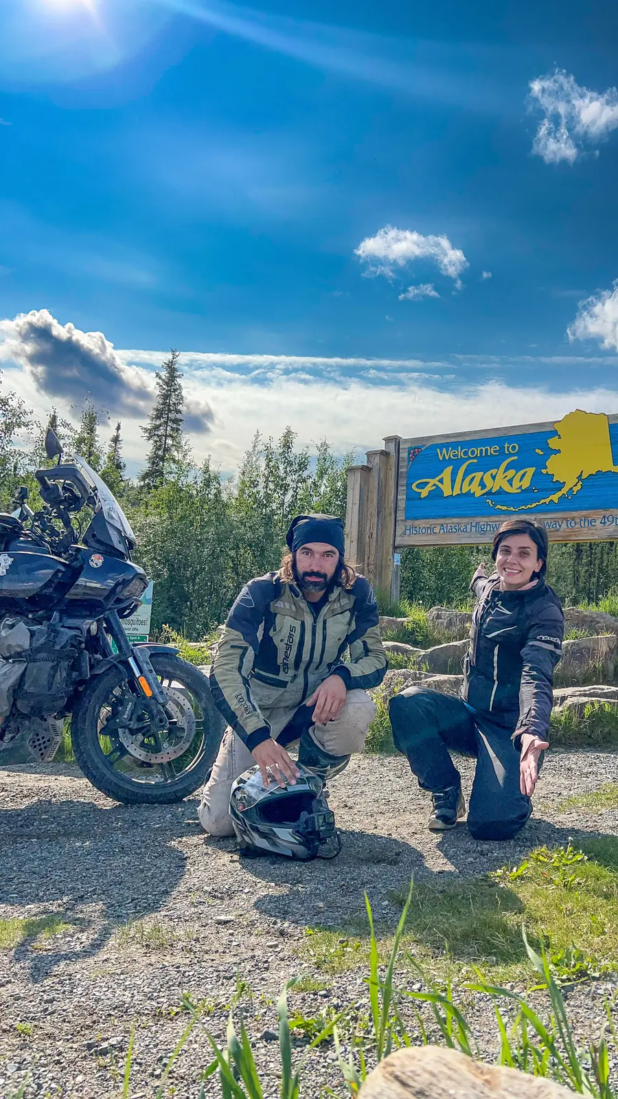 Ton e Nay com a moto na placa de boas-vindas do Alasca