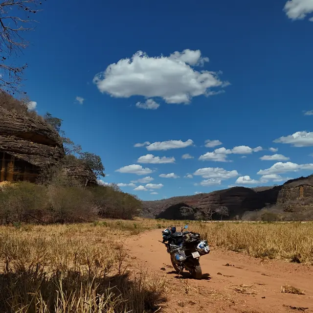Moto em trilha de terra entre paredões de pedra