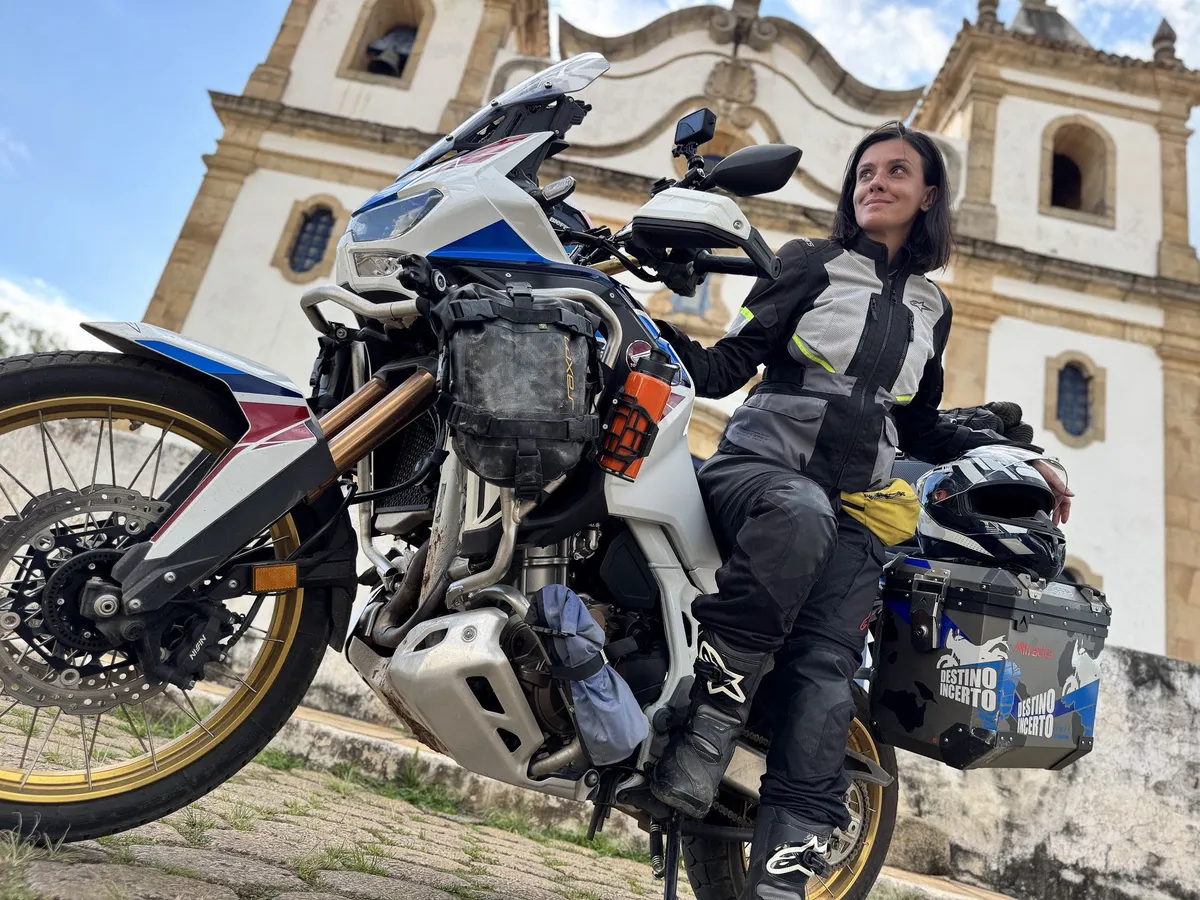 Nay sentada na moto em frente a uma igreja histórica