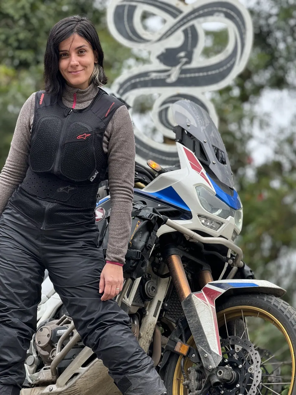 Nay de pé ao lado da moto
